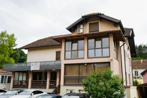 a house with cars parked in front of it at D apartmani in Sremska Kamenica