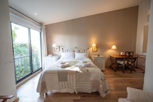 a bedroom with a bed and a large window at Hotel Casagrande in Paysandú