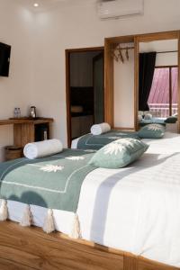 two beds sitting next to each other in a room at Luciana Hotel in Labuan Bajo