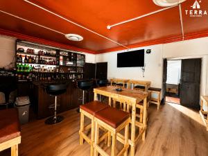 a bar with wooden tables and chairs and a television at Terra House Hostel in Cusco