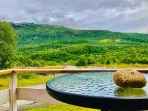 a large pool of water with a rock in it at Sobakken Camping in Bardu
