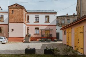 a white house with yellow doors in a courtyard at Buntes nams l Self check-in l Private entrance in Limbaži