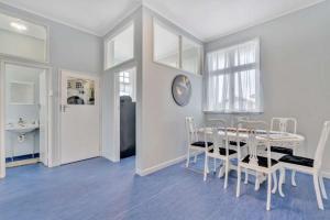 a white dining room with a table and chairs at Ruawai Post Office Accommodation in Ruawai +4 photos