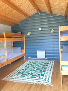 a room with two bunk beds and a blue wall at Sobakken Camping in Bardu