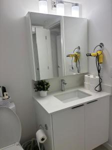 a white bathroom with a sink and a mirror at Cozy 1 bed and 1 bath in Surrey +19 photos