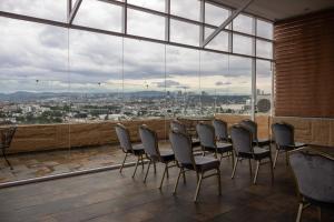 a room with chairs and a table and a large window at Hotel Crown Victoria in Querétaro
