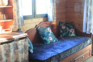 a bed in a cabin with two pillows on it at roulotte de charme avec jacuzzi privé in Beaupouyet