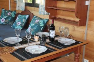 a table with a bottle of wine and glasses on it at roulotte de charme avec jacuzzi privé in Beaupouyet +50 photos