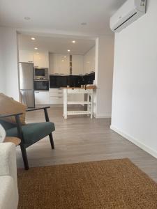 a living room with a couch and a table and a kitchen at Refúgio da Barra in Gafanha da Nazaré +2 photos