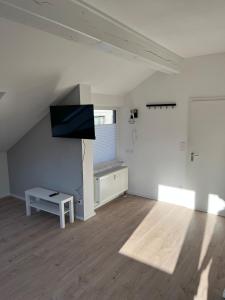 an empty living room with a tv and a table at Stylish & modern Flat with large Sun Balcony in Bad Peterstal