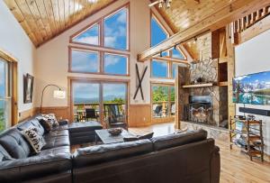 a living room with a leather couch and a fireplace at Pinecone Manor Beech Mountain in Beech Mountain