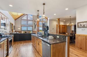 a large kitchen with wooden cabinets and a large window at Pinecone Manor Beech Mountain in Beech Mountain +29 photos