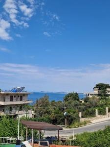 a view of the ocean and a house with a roof at Sunset Panorama Residence in Vlorë