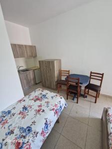 a bedroom with a bed and two chairs and a table at Sunset Panorama Residence in Vlorë