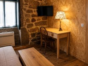 a room with a desk with a lamp and a chair at Casas da Villa- Monsanto in Monsanto