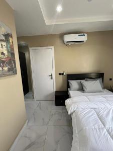 a bedroom with a white bed and a white door at Pcg Homes in Lagos