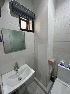 a white bathroom with a sink and a mirror at Pcg Homes in Lagos
