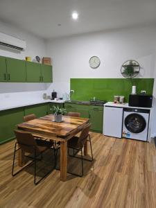 a kitchen with a wooden table and green cabinets at The Cozy Cottage-With elevated views in Queenstown