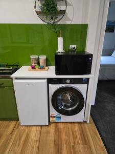 a washing machine with a microwave on top of it at The Cozy Cottage-With elevated views in Queenstown +14 photos