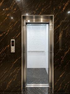 a glass door in a wall with a mirror at JK Suites in Rāmachandrapuram +12 photos