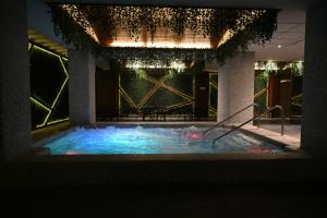 a large swimming pool in a building with a lighting at Hotel Crown Victoria in Querétaro