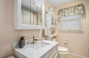 a white bathroom with a sink and a toilet at Perfect Cape Escape ! in Harwich +32 photos