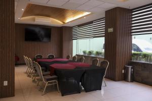 a dining room with a black table and chairs at Hotel Crown Victoria in Querétaro +28 photos