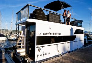 two people on a boat at a dock at Duerme en un barco in Moaña