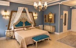 a bedroom with a large bed and a chandelier at Hostal Boutique Puerta del Sol in Torrelavega