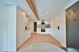 an open kitchen with white cabinets and a ceiling at Hotel M&H Apartments - Salzgitter in Salzgitter
