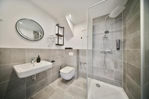 a bathroom with a sink toilet and a mirror at Hotel M&H Apartments - Salzgitter in Salzgitter