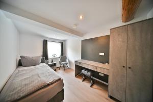 a bedroom with a bed and a desk in a room at Hotel M&H Apartments - Salzgitter in Salzgitter +32 photos