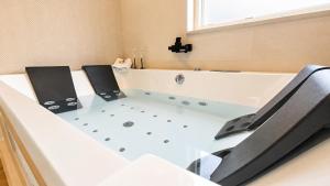 a bath tub with two chairs sitting next to it at O Retiro da Costa Galitrips in Muxia +31 photos