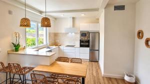 a kitchen with white cabinets and a wooden table at O Retiro da Costa Galitrips in Muxia