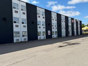 ein großes Gebäude mit weißen Türen an einer Straße in der Unterkunft Premium Inn & Suites in Calgary