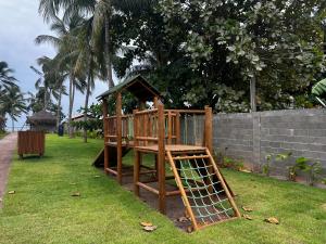 a wooden playground with a ladder and a house at Condo with Beach Access By MME in Tatuamunha