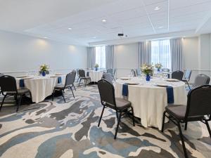 a conference room with tables and chairs with flowers on them at voco Sarasota by IHG in Sarasota +54 photos