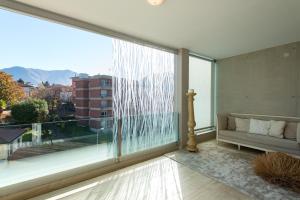 ein Wohnzimmer mit einem großen Fenster und einem Sofa in der Unterkunft DL Boutique Apartments in Lugano