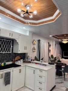 a kitchen with white cabinets and a ceiling at The Rose Garden in Georgetown