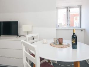 a white dining room table with a bottle of wine on it at 2 person holiday home in Ringkøbing in Ringkøbing