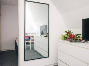 a mirror on a wall next to a dresser at 2 person holiday home in Ringkøbing in Ringkøbing +20 photos
