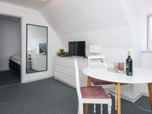 a white dining room with a table and a mirror at 2 person holiday home in Ringkøbing in Ringkøbing