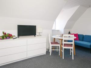 a living room with a tv and a table with a blue couch at 2 person holiday home in Ringkøbing in Ringkøbing
