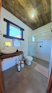 a bathroom with a toilet and a sink and a shower at Casa Cambuí Hospedagem Rural in São José do Rio Preto