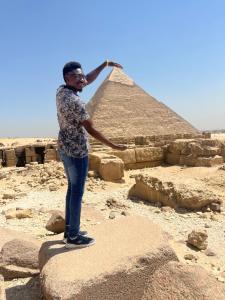 a man standing in front of the pyramids at Farida Pyramids inn& Jacuzzi in Cairo