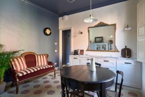 a kitchen with a table and a chair and a mirror at Boutique Apartment nel Borgo - Casa Olga e Casa Ilde - Le Dimore del centro in Santarcangelo di Romagna