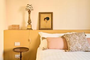 a bedroom with a bed with a lamp and a table at Boutique Apartment nel Borgo - Casa Olga e Casa Ilde - Le Dimore del centro in Santarcangelo di Romagna