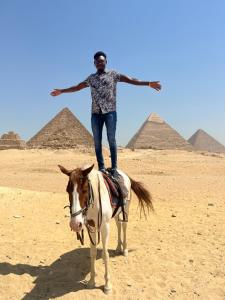 a man riding a horse in front of pyramids at Farida Pyramids inn& Jacuzzi in Cairo