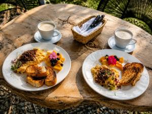 a table with two plates of food and two cups of coffee at UKO Urbanekolodge in Armenia