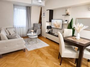 a living room with a dining room table and a couch at Apartment 88 SELF check-in, FREE parking in Skopje